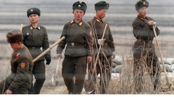 North Korean soldiers seen working with shovels on Hwanggumpyong Island, opposite the Chinese border.