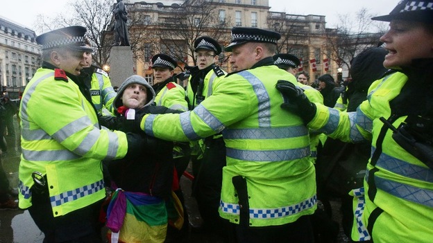 Police talk to a man during a Thatcher's dead 'party', organised via Facebook, in Trafalgar Square.