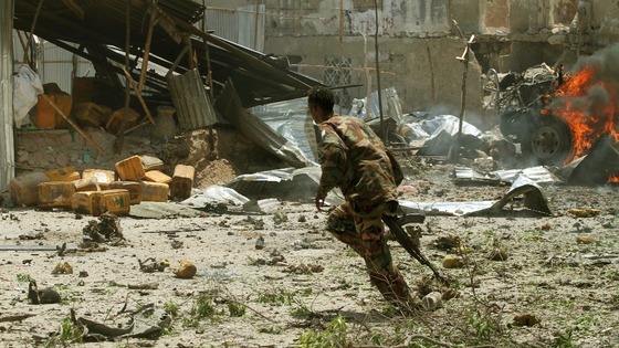 A Somali soldier runs near the scene of a deadly blast in Mogadishu