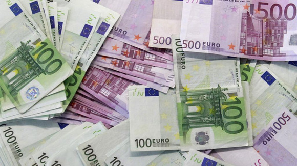 Euro notes are spread out at a bank branch in Madrid