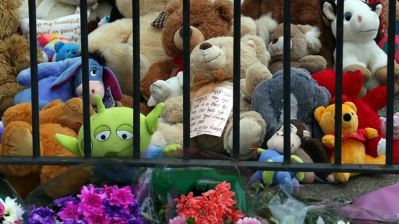 Flowers, bears and other toys have been left outside the house.