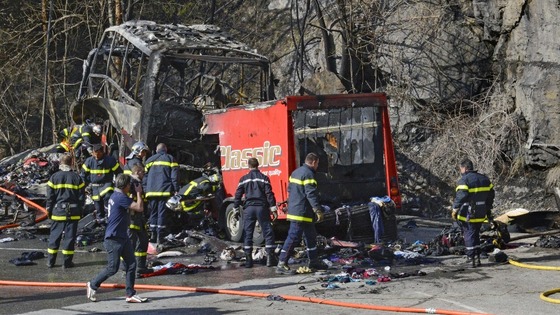 French fire brigade members work around the debris from the crashed bus. 