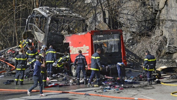 French fire brigade members work around the debris from the crashed bus.