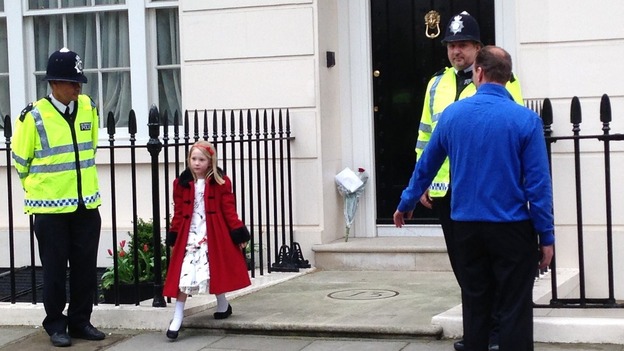 A young girl lays flowers outside Margaret Thatcher's Belgravia home ahead of the family's departure for funeral.
