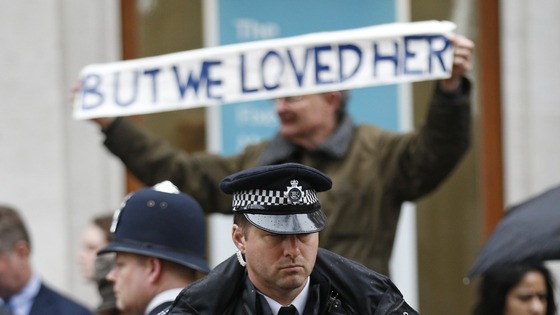 A supporter of Margaret Thatcher lines the route of her funeral procession, outside St Paul's cathedral, London