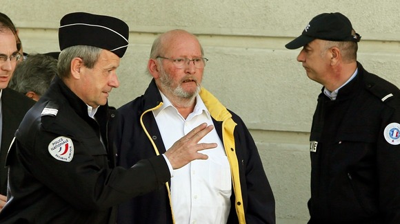 PIP founder Jean-Claude Mas (C) is surrounded by policemen as he arrives at the courthouse in Marseille