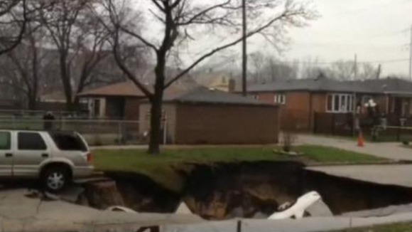 Three cars slid into the sinkhole and a fourth was towed from the edge
