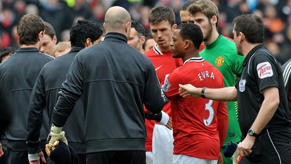 Luis Suarez (L) refuses to shake Patrice Evra's hand at Old Trafford