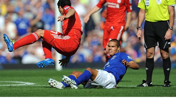 Everton's Jack Rodwell (floor) goes in for a tackle against Luis Suarez which earns him a red card for serious foul play