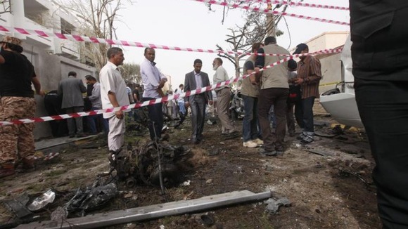 People stand in the wreckage of the apparent car bomb outside the French embassy in Tripoli