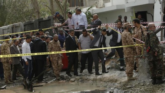 Libyan Interior Minister Ashour Shuail (C) inspects the scene near the French embassy in Tripoli, after it was hit by an apparent car bomb