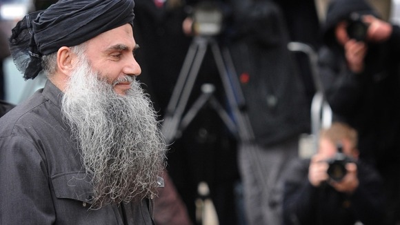 Abu Qatada surrounded by the media in London