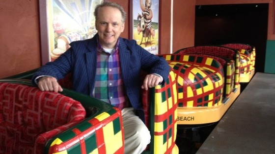 Animator Nick Park sitting in one of the slipper shaped cars on the new ride.