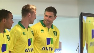 Norwich City captain Grant Holt shows off the club's new home strip with teammates