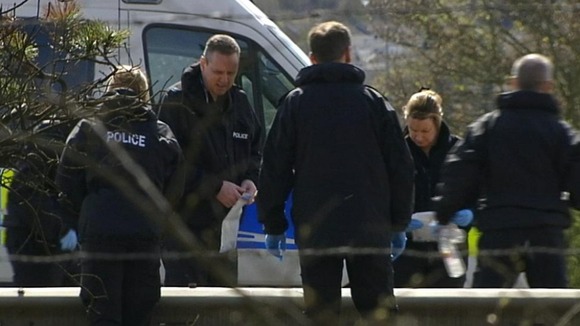 Forensic teams search the carriageway yesterday
