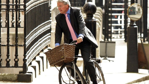 Andrew Mitchell rides his bicycle around Westminster