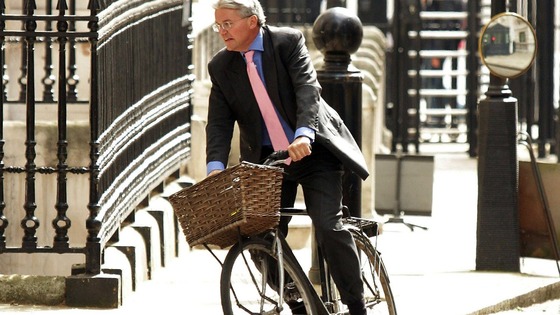 Andrew Mitchell rides his bicycle around Westminster