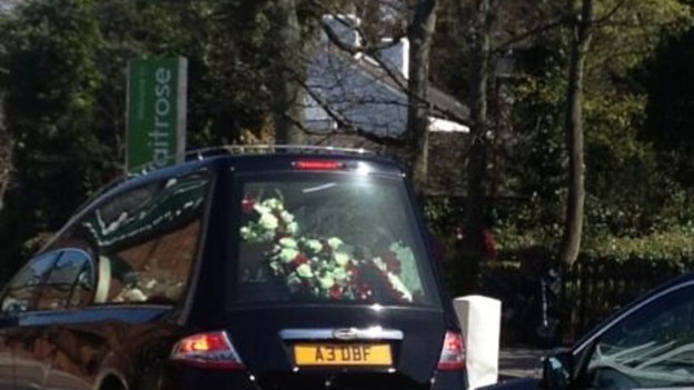 Cortege carrying Anne Williams decked out inn red and white flowers approaches the church
