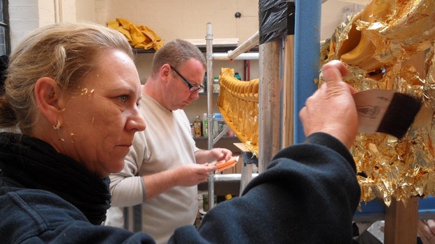 Craftsmen apply gold leaf.