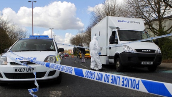 Forensic police officers examine evidence at the crime scene where two men escaped from a prison van that came under attack in Salford