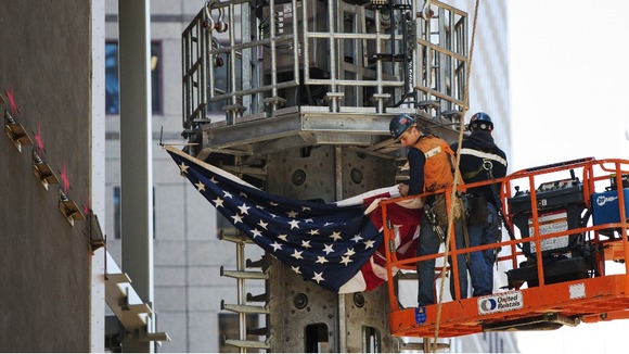 Ground Zero workers attach a US flag t the spire