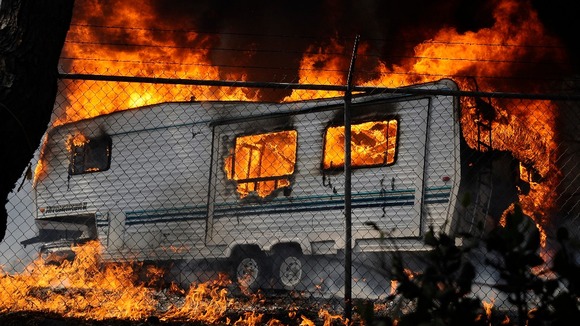 A trailer is engulfed in flames as a wildfire pushes towards the coast in Camarillo