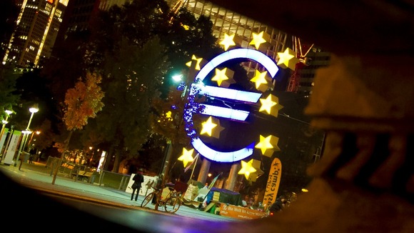 The Euro sculpture is seen behind a fountain statue at Willy-Brandt-Platz in Frankfurt.