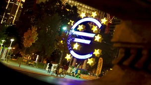The Euro sculpture is seen behind a fountain statue at Willy-Brandt-Platz in Frankfurt.