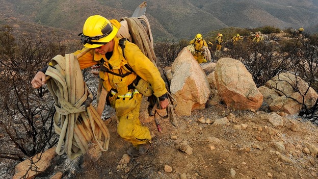 Firefighters make their way out of a canyon as they battle the Springs Fire near Malibu, California.