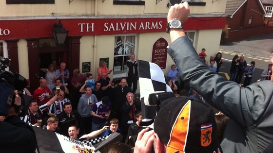 Crowds welcome Spennymoor Town FC victory bus.