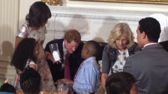 Prince Harry watches as children make presents for their mothers at the White House.