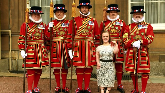 Paralympic swimmer Ellie Simmonds with members of the Yeoman of the Guards after receiving her OBE.