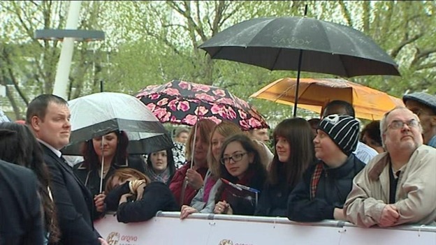 Members of the public dressed in wet weather gear wait patiently for the arrival of actors at BAFTA Awards