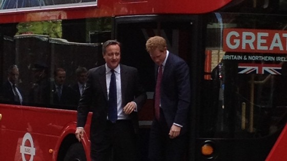 David Cameron and Prince Harry emerge from the Routemaster