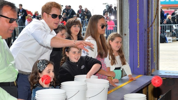 Prince Harry tries his hand at a fairground stall in Mantoloking, a borough of Ocean Heights, New Jersey