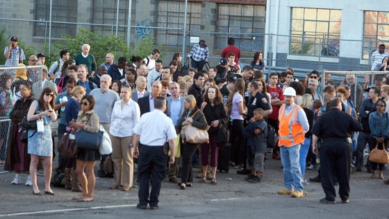 Passengers wait to be picked up by bus after two commuter trains collided in Bridgeport, Connecticut