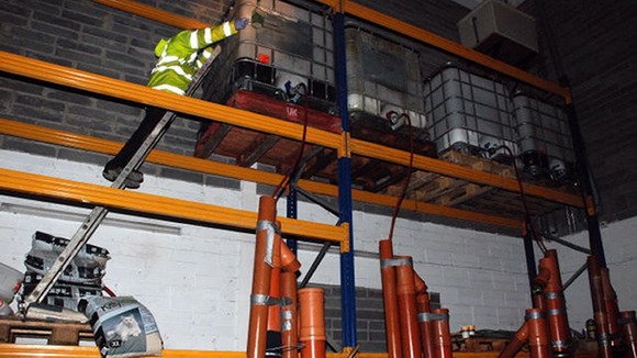 A customs official looks inside a tank at the plant