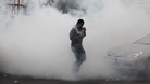 A demonstrator runs through a cloud of tear gas fired by police during a protest in the village of Diraz, west of Manama.
