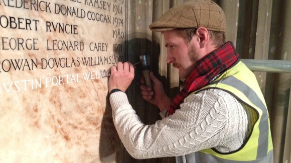 Craftsman Benn Swinfield carefully carves Archbishop Justin Welby's name