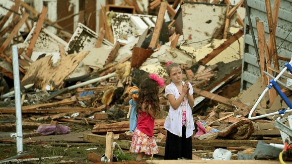 Two girls stand in the rubble after the tornado hits Moore, Oklahoma.