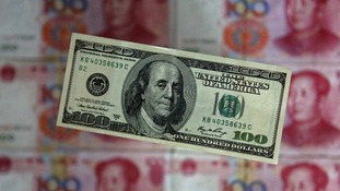 The US dollar displayed in front of the yuan banknotes.