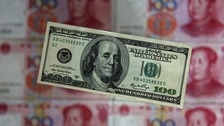 The US dollar displayed in front of the yuan banknotes.