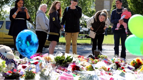 People gather around the floral tributes to Lee Rigby