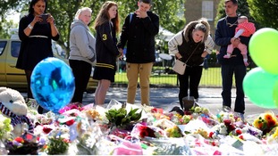 People gather around the floral tributes to Lee Rigby