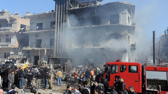 Syrian security members inspecting damaged building after explosions near the intelligence forces in Damascus, March 17, 2012.
