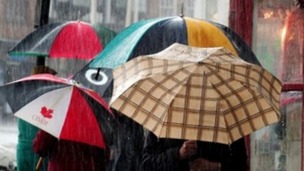 People carrying umbrellas in the rain.