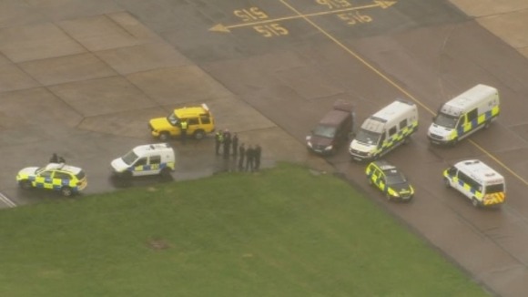 Police vehicles pictured next to the PIA plane at Stansted Airport.