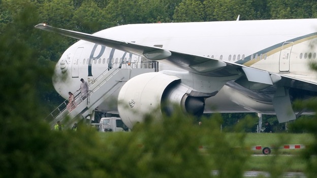 Passengers disembark the PIA flight PK709 at Stansted Airport after it is diverted.