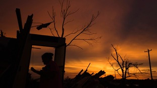 A woman walks past the open door of her uncle's former home in Moore, Oklahoma.