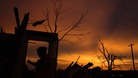 A woman walks past the open door of her uncle's former home in Moore, Oklahoma.